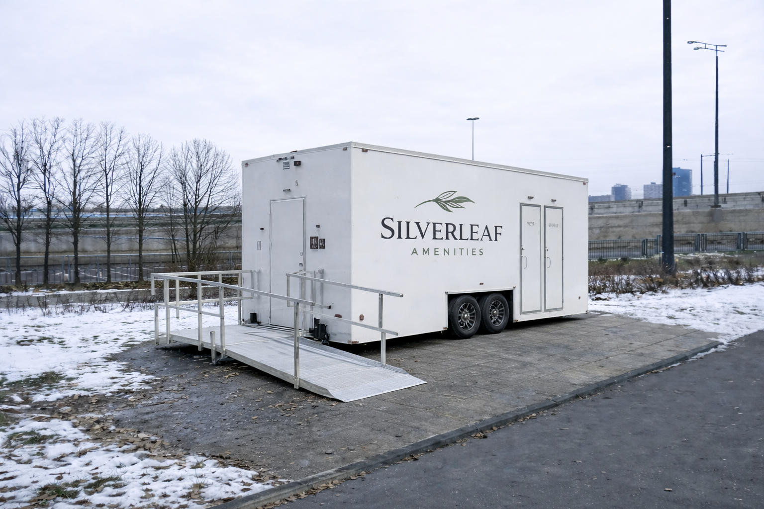 ADA restroom trailer with wheelchair ramp set up outdoors in winter by Silverleaf Amenities in Colorado