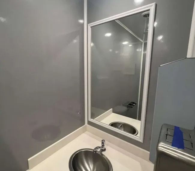 Modern sink and vanity inside a luxury restroom trailer with mirror and countertop, available for event and construction rentals in Colorado