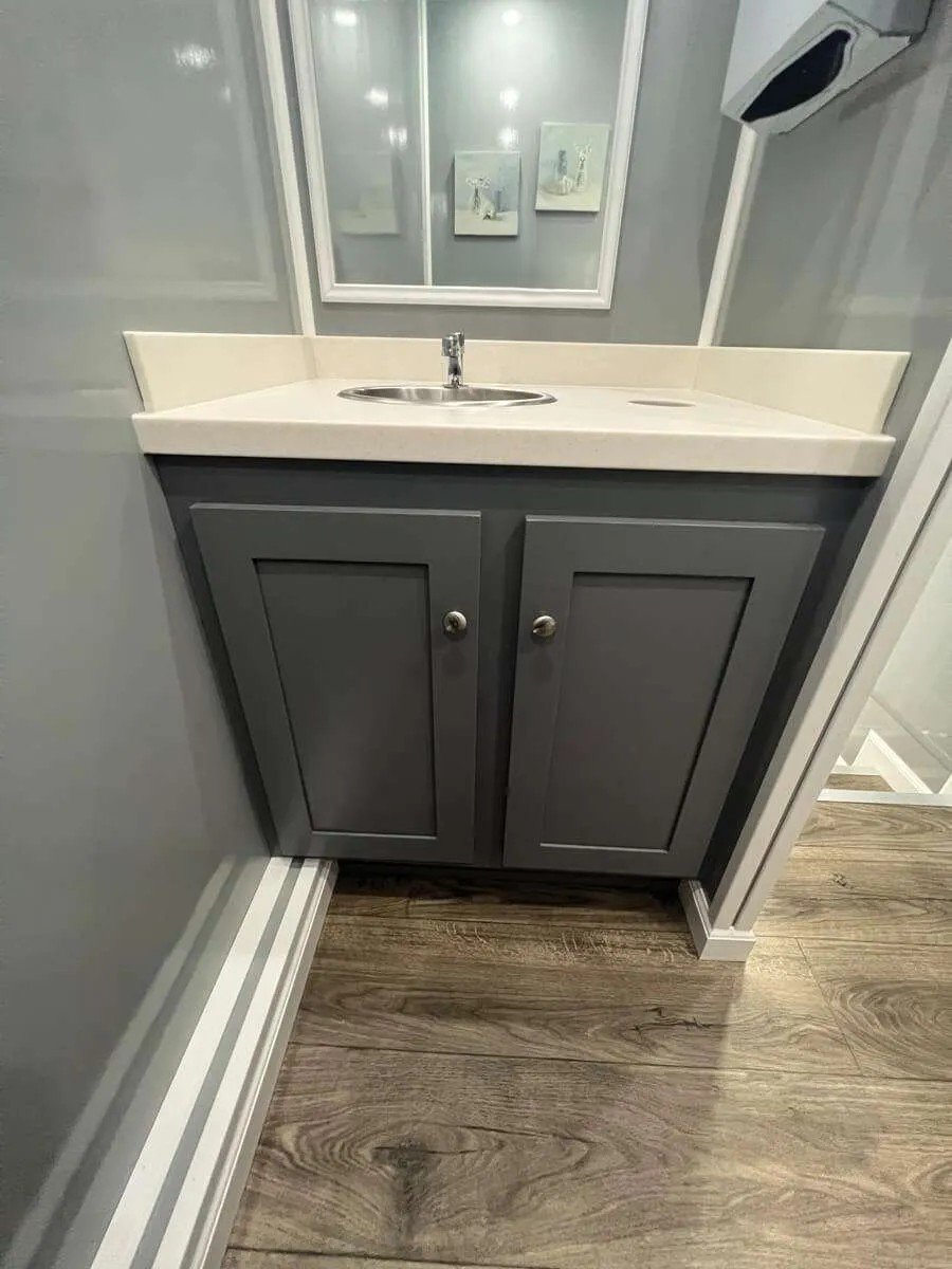Modern vanity cabinet with sink inside a luxury restroom trailer, featuring premium interior finishes for event and construction rentals in Colorado