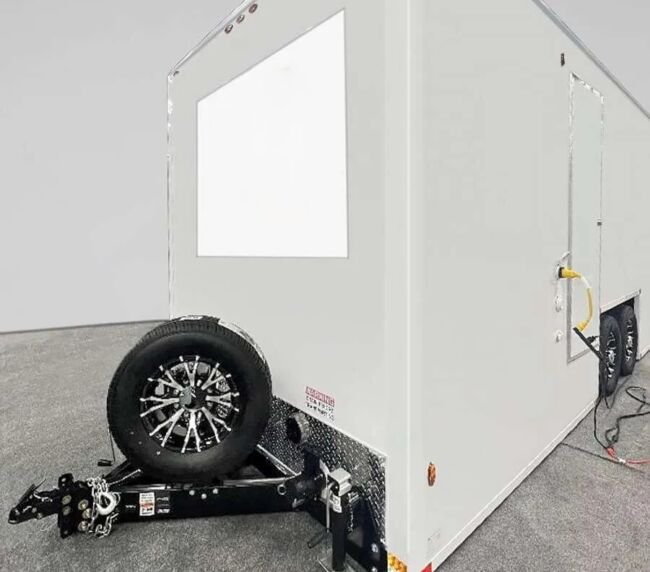 Front hitch view of a portable restroom trailer showing towing setup, available for event and construction rentals in Colorado