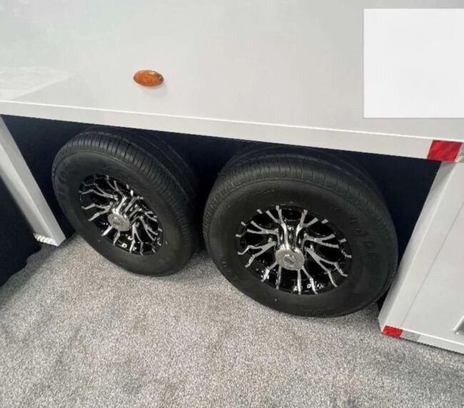 Close-up of dual axle wheels on a portable restroom trailer, designed for easy transport across Colorado job sites and events